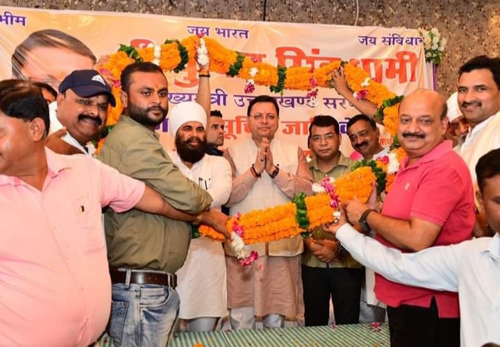 CM धामी का वाल्मीकि समाज एवं पर्यावरण मित्रों द्वारा पगड़ी पहनाकर तथा पुष्पवर्षा कर स्वागत किया